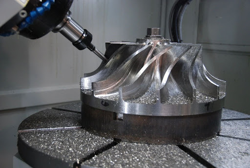 The incredible part of 5-axis CNC machining lies within the integration of simplification and complexity in the manufacturing process. All that for an intricate design, high precision, and quicker production time offers it all. But with this power comes a set of challenges. Manufacturers applying 5-axis CNC machines often face challenges that might affect productivity, precision, and cost efficiency. In this blog, we'll examine the issues with 5 axis CNC machining services and how you can overcome them so that manufacturers can take full advantage of this leading-edge technology. What is 5-Axis CNC Machining? The possibility of such 5-axis CNC machining is due to moving cutters or parts along five axes at the same time. Unlike conventional 3-axis machines, which can have three linear axes (X, Y, and Z), the 5-axis machine further provides two rotational axes (A and B) that provide more flexibility in manufacturing complex parts in a single set-up. In aerospace, automotive, and medical device manufacturing industries, the process relies heavily on precision and complexity. Real-World Challenges in 5-Axis CNC Machining Complex Programming Requirements One of the big challenges with 5-axis CNC machining lies in the complexity of the programming that needs to be done. There are five axes to a movement, and programming a machine to make the right tool path is complex work that requires superior knowledge. A small programming mistake may cause a tool collision, part errors, or even damage to the machine. Solution: Further investment in advanced CAM software is required for simpler programming processes. The new CAM software will be able to produce optimal tool paths with minimal chances of errors and avoid collisions while machining. In addition, operators need periodic training sessions regarding the use of CAM software to keep production intact. Tool Accessibility and Interference With easier access to the required tools, 5-axis machining results in more complicated geometries of parts. Since the cutting tool can access the workpiece from multiple angles, it enhances the chances that it may collide with the workpiece or fixture, or even collide with the machine itself. Solution: Toolpath planning, optimized, avoids interference between two or more tools. Simulation software lets you visualize the whole machining process ahead of time and avoid interference between the tool and parts of the machine or a fixture. Using even shorter and stiffer tools will ultimately lead to reduced risk from vibration and interference. Workholding and Fixturing Challenges It is more difficult to hold a workpiece in place during 5-axis machining services than it is to maintain it during traditional machining. The parts are rotated along their axes, and it may not be possible for them to sit steadily through the entire process. Poor fixturing allows the part to move, compromising quality and accuracy. Solution: Often, a custom-designed fixture is required with 5-axis machining. These fixtures need to be stiff enough to withstand complex motions without compromising the precision of the part. Another alternative is the modular workholding system, which allows easy adjustment and flexibility in terms of machining different parts. Tool Wear and Tool Life Management The 5-axis machining puts more wear and tear on the tools, especially for such tools, owing to cutting angles being unconventional or to long production runs on the machine. Tool wear could lead to bad-quality parts and costlier downtime unless managed well. Solution: This problem can be solved by inspecting the tools at regular intervals and having a tool management system in place. Most 5-axis CNC machines are supplied with a tool monitoring system that detects wear patterns, enabling one to plan for predictive maintenance. Long tool life can also be achieved by using quality cutting tools tailored to 5-axis machining applications. Thermal Stability and Accuracy Since 5-axis machines work for relatively long periods of time, thermal expansion becomes an issue for both the machine itself and its workpiece, affecting the desired accuracy of the produced part. The biggest problem areas in this sense are the aerospace and medical devices industries, where even the tiniest deviation might make the particular part useless. Solution: Thermally controlled environments and machines with thermal compensation features can negate the effects of thermal expansion. A lot of newer 5-axis machines have sensors that adjust the path that the tool takes and machine movement based on real-time reading of temperature. Also, allowing machines to warm up before utilizing it at high precision helps in minimizing errors. Machine Calibration and Maintenance 5-axis CNC machines are more complicated. Thus, they require time-to-time calibration and maintenance. Calibration errors may result in generating incorrectly manufactured parts, whereas partial maintenance may lead to machine breakdown, which is instead a costly form of delay. Solution: To prevent getting the best out of 5-axis CNC machines, the maintenance and calibration schedule should be established. Specific alignment, lubrication, and tool integrity checks must be conducted to the operators with regard to the assurance of results as precise. However, in many cases, there will be a manual check to be carried out within time to prevent those potential hazards. Conclusion While there are indeed real-world challenges with 5-axis CNC machining, the proper strategies, tools, and technologies can certainly overcome those challenges. Manufacturers can exploit the full capabilities of 5-axis machines for the efficient production of high-precision complex parts. We are proud to be at the front in 5-axis CNC machining services for unmatched precision. We are fully empowered to produce even the most intricate, high-tolerance parts for clients of high standards of quality and efficiency.
